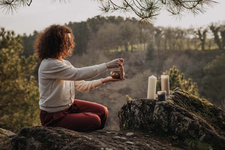 femme en communion avec la nature qui allume des bougies et encens en extérieur, séance photo isabelle lechevallier