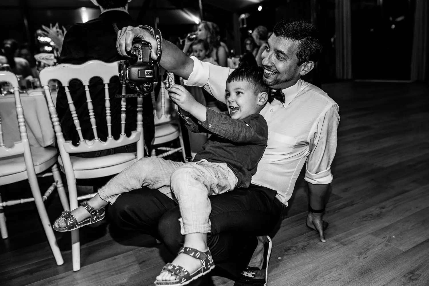 moment complice d'un papa avec son fils durant une soirée de mariage